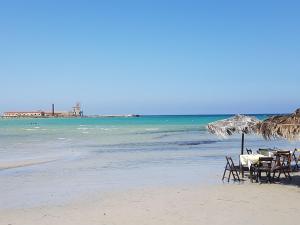 un tavolo e sedie su una spiaggia con l'oceano di ZEFIRO a Marsala
