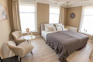 a bedroom with a bed and a table and chairs at Hotel Restaurant Toxopeus in Anjum