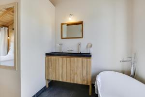a bathroom with a sink and a mirror at Villa Mimbeau in Cap-Ferret