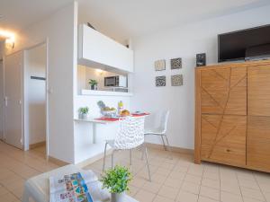 a small living room with a table and a chair at Apartment Les Trois Mâts-4 by Interhome in Canet-en-Roussillon