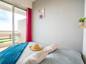 einen Hut auf einem Bett in einem Zimmer in der Unterkunft Apartment Les Terrasses du Levant-5 by Interhome in Canet-en-Roussillon