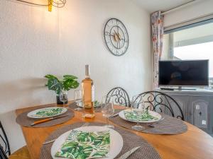 einen Esstisch mit einer Flasche Wein und Gläsern in der Unterkunft Apartment Les Terrasses du Levant-5 by Interhome in Canet-en-Roussillon