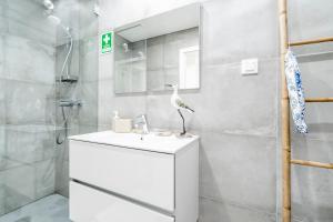 a bathroom with a white sink and a shower at Coastal Holiday´s Apartment in Monte Gordo