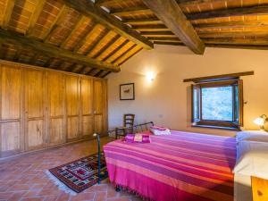 una camera con un grande letto in una stanza con soffitti in legno di Holiday Home Bramasole by Interhome a Cortona