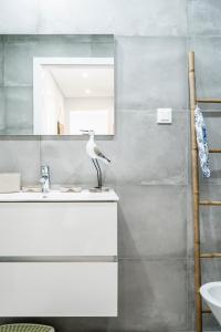 een badkamer met een vogel op een wastafel bij Coastal Holiday´s Apartment in Monte Gordo