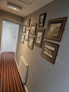 a hallway with a bunch of pictures on a wall at Shears Inn in Halifax