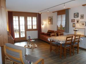 a living room with a table and a couch at Apartment Chalet Cortina by Interhome in Grindelwald