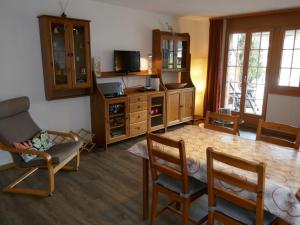 Apartment Chalet Cortina by Interhome في جريندلفالد: غرفة معيشة مع طاولة طعام وكراسي
