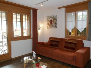 Apartment Chalet Cortina by Interhome في جريندلفالد: غرفة معيشة مع أريكة وطاولة زجاجية