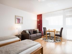 ein Schlafzimmer mit einem Bett, einem Sofa und einem Tisch in der Unterkunft Apartment B915 by Interhome in Lahnstein