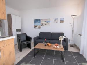 ein Wohnzimmer mit einem Sofa und einem Tisch in der Unterkunft Apartment Küstenoase by Interhome in Norddeich