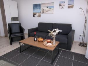 ein Wohnzimmer mit einem Sofa und einem Tisch in der Unterkunft Apartment Küstenoase by Interhome in Norddeich
