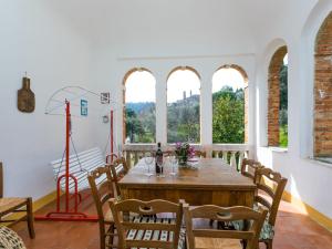 een eetkamer met een tafel, stoelen en ramen bij Holiday Home Podere Casina by Interhome in Sinalunga