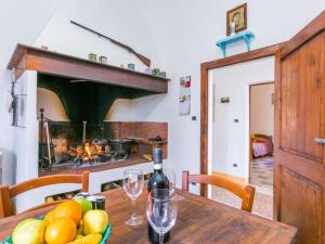 een tafel met een fles wijn en een fruitschaal bij Holiday Home Podere Casina by Interhome in Sinalunga