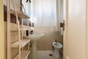 ein kleines Bad mit einem Waschbecken und einem WC in der Unterkunft Casa della Sabina by BarbarHouse in Maruggio