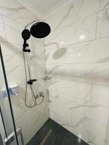 a bathroom with a shower with white marble walls at The Marist Hotel Kadikoy in Istanbul