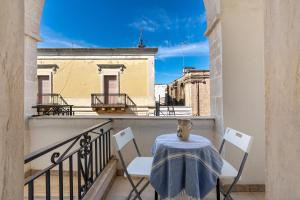 a balcony with a table and chairs on a balcony at Casa della Sabina by BarbarHouse in Maruggio