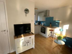 a living room with a tv and a kitchen at 37 Strawberry Hill, Hayle in Hayle