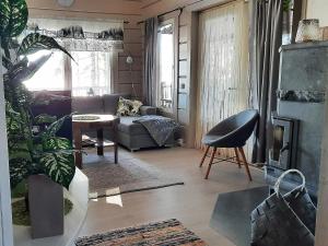 ein Wohnzimmer mit einem Sofa und einem Stuhl in der Unterkunft Holiday Home Loisteranta by Interhome in Vääräkoski