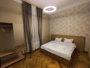 a bedroom with a bed with two towels on it at Cozy Apartment In Old Town Kutaisi in Kutaisi