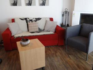 a living room with a red couch and a chair at Apartment Bierlialp-Park A35 by Interhome in Engelberg