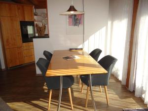 a dining room table with chairs and a lamp at Apartment Bierlialp-Park A35 by Interhome in Engelberg
