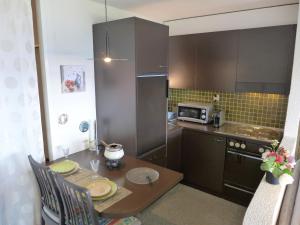 a small kitchen with a table and a microwave at Studio Jeanne d'Arc-11 by Interhome in Crans-Montana