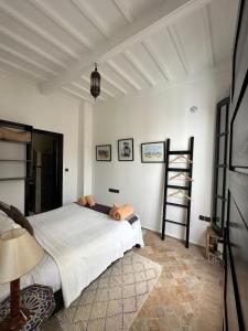 Un dormitorio con una cama y una escalera. en Riad Dar Awil, en Essaouira