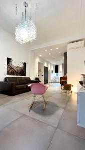 - un salon avec une chaise rose et un canapé dans l'établissement Apartment via Ferrucci 22, à Milan