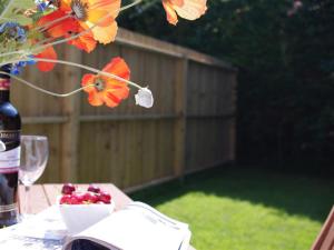 uma mesa com uma garrafa de vinho e uma taça de flores em Holiday Home Eglos by Interhome em Saint Merryn