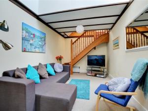 uma sala de estar com um sofá e uma televisão em Holiday Home Eglos by Interhome em Saint Merryn