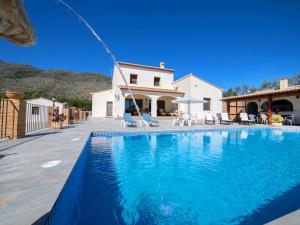 a swimming pool in front of a house at Holiday Home Los Olivos by Interhome in Benimallunt