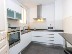 a white kitchen with a sink and a microwave at Apartment Eix-Dret-Roger de LLuria-Valencia by Interhome in Barcelona