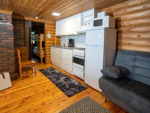 eine Küche mit einem Kühlschrank und einem Sofa in einem Zimmer in der Unterkunft Holiday Home Kalliorinne by Interhome in Kolu