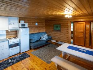 eine Küche und ein Wohnzimmer mit einem Sofa in einer Hütte in der Unterkunft Holiday Home Kalliorinne by Interhome in Kolu