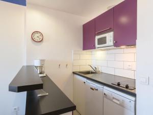 アルカションにあるStudio Feodorowka-1 by Interhomeのキッチン(紫色のキャビネット、シンク、時計付)