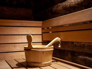 a wooden bucket with a spoon in it next to a bench at Chalet Papillon by Interhome in Nendaz
