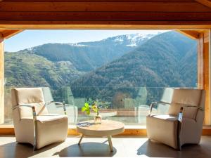 a room with two chairs and a table in front of a window at Chalet Papillon by Interhome in Nendaz