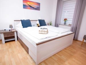 ein großes weißes Bett in einem Zimmer mit Fenster in der Unterkunft Apartment Seegras by Interhome in Norddeich