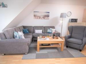 ein Wohnzimmer mit einem Sofa und einem Tisch in der Unterkunft Apartment Seegras by Interhome in Norddeich
