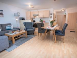 ein Wohnzimmer und eine Küche mit einem Tisch und Stühlen in der Unterkunft Apartment Seegras by Interhome in Norddeich