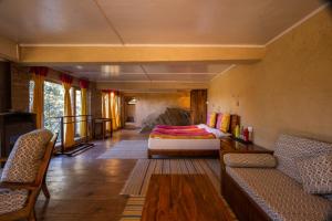 sala de estar con 1 cama y 2 sillas en Binsar Forest Retreat en Binsar