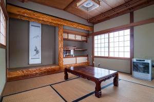 a room with a table and two windows at Immaculate Private Family Cottage with Hot Spring in Towada