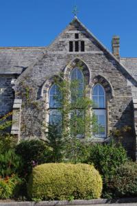 an old stone building with a cross on top of it at Holiday Home Old School House by Interhome in Padstow