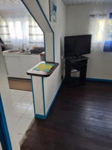 ein Wohnzimmer mit einer Treppe, einem TV und einem Tisch in der Unterkunft Résidence JB in Sinnamary