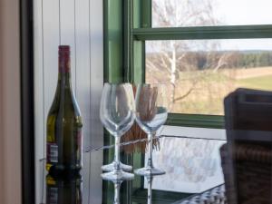 Dois copos de vinho e uma garrafa no peitoril da janela. em Apartment B 77 by Interhome em Dittishausen