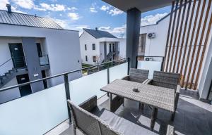 eine Terrasse mit einem Tisch und Stühlen auf dem Balkon in der Unterkunft Apartments Sunrise Banovci in Banovci