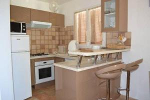 a kitchen with a white refrigerator and a counter top at Maison Les Pieds dans l eau in Farinole +6 photos