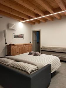 a large bed in a room with wooden ceilings at SEMI AL VENTO: la bio-casa nel giardino incantato! in Paesana