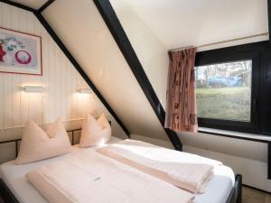 a bedroom with a white bed with a window at Holiday Home Waldferienpark Gerolstein-11 by Interhome in Gerolstein